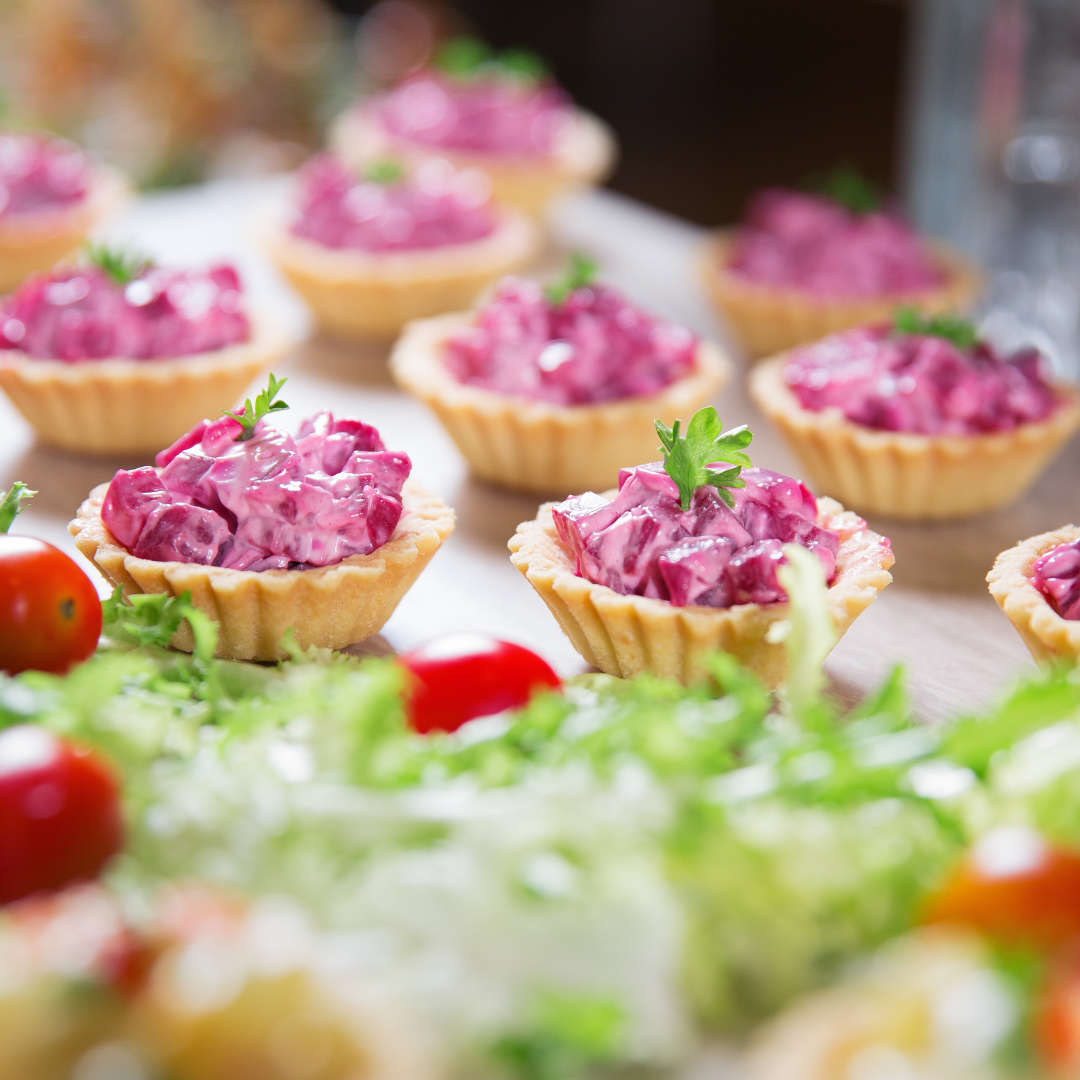 Canapes topped with beetroot on a catering tray