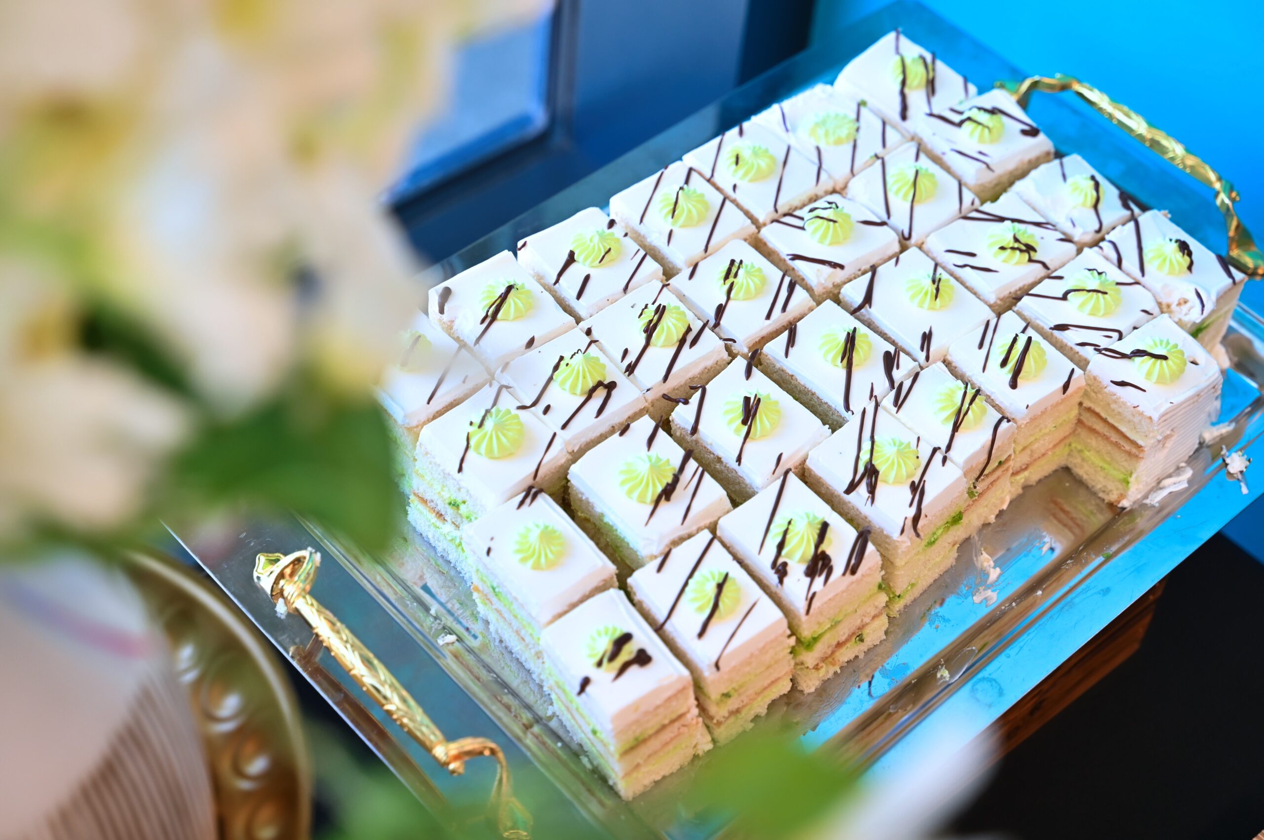 Mayuri catering stand set up at an event with signage and flowers
