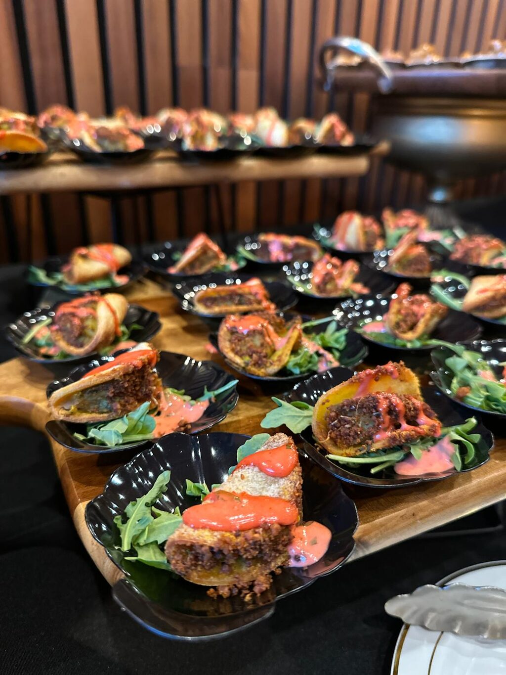 Fusion canapes and taco style snacks on a serving board