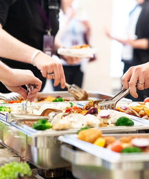 Close up of hands scooping food. Buffet catering meal concept.